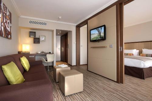une chambre d'hôtel avec un canapé et un lit dans l'établissement AC Hotel by Marriott Ambassadeur Antibes - Juan Les Pins, à Juan-les-Pins