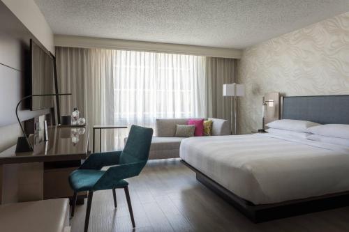 une chambre d'hôtel avec un lit et une chaise dans l'établissement Miami Airport Marriott, à Miami