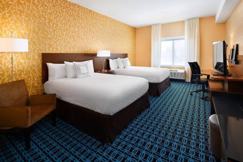 um quarto de hotel com duas camas e uma secretária e uma televisão em Fairfield Inn & Suites by Marriott Fresno Yosemite International Airport em Fresno
