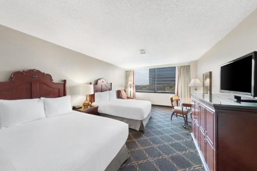 a hotel room with a bed and a flat screen tv at Austin Southpark Hotel in Austin