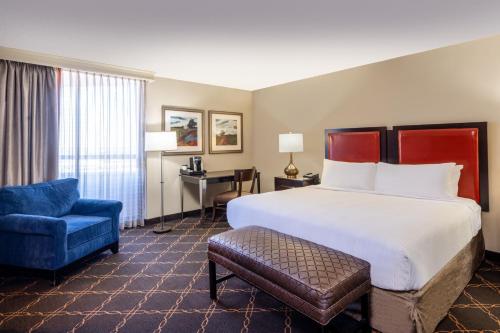 Habitación de hotel con cama y silla azul en Austin Southpark Hotel en Austin