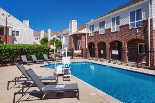 une piscine avec des chaises longues et un bâtiment dans l'établissement Residence Inn Philadelphia Willow Grove, à Horsham