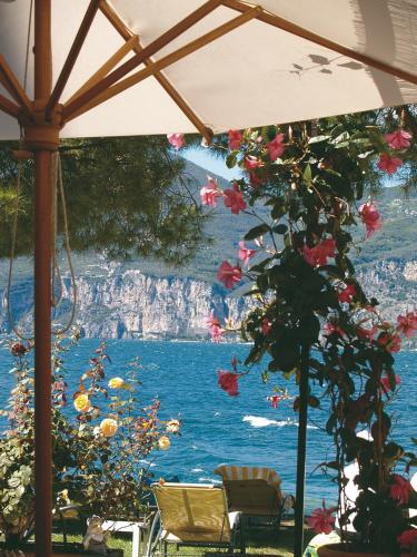a view of the ocean from under an umbrella at Hotel Du Lac - Relax Attitude Hotel in Brenzone sul Garda