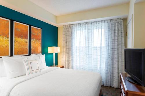 - une chambre avec un lit et une grande fenêtre dans l'établissement Residence Inn Louisville Northeast, à Louisville