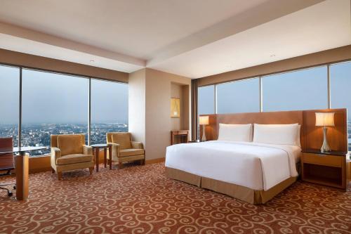 a hotel room with a bed and large windows at JW Marriott Hotel Medan in Medan