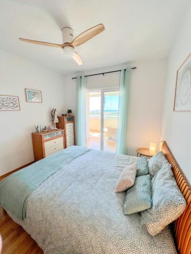 sypialnia z łóżkiem i wentylatorem sufitowym w obiekcie Bright apartment with terrace, pool and beach w mieście Torremolinos
