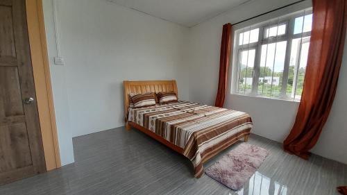 sypialnia z łóżkiem i oknem w obiekcie Cozy Appartment w mieście Trianon