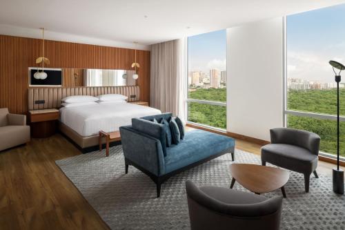Barranquilla Marriott Hotel في بارانكويلا: غرفة فندقية بسرير ونافذة كبيرة