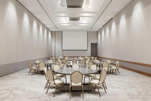 a conference room with tables and chairs and a whiteboard at Barranquilla Marriott Hotel in Barranquilla