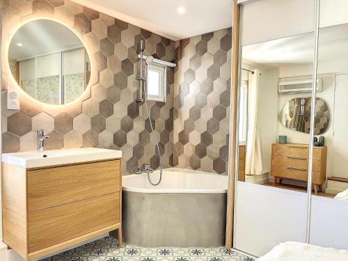 bagno con vasca, lavandino e specchio di Cocon Forville - Palais des Festivals, Plages, clim a Cannes