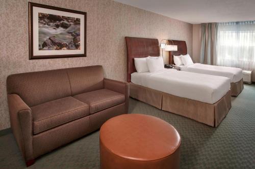 una camera d'albergo con due letti e un divano di Fairfield Inn & Suites by Marriott Great Barrington Lenox/Berkshires a Great Barrington