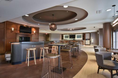a restaurant with a bar with chairs and tables at SpringHill Suites Columbia Downtown The Vista in Columbia