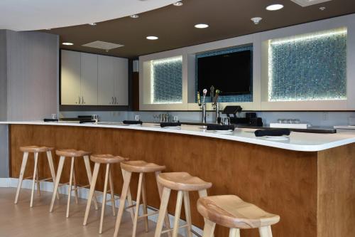 a large kitchen with stools at a bar at SpringHill Suites Columbia Downtown The Vista in Columbia