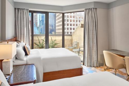 a hotel room with two beds and a large window at Metropolitan Hotel Vancouver in Vancouver