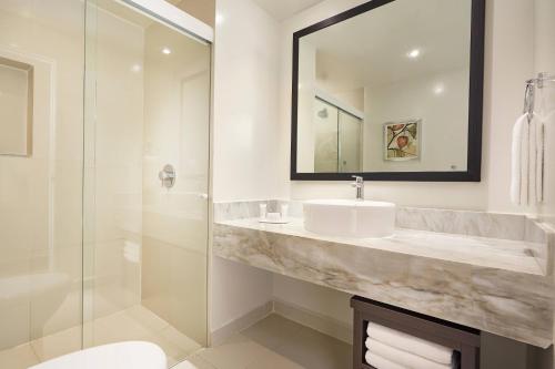 a bathroom with a sink and a mirror and a shower at Fairfield Inn & Suites by Marriott Villahermosa Tabasco in Villahermosa