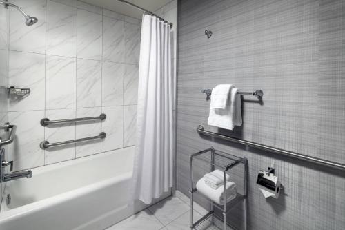 a bathroom with a shower and a tub and a toilet at Sheraton Grand Los Angeles in Los Angeles