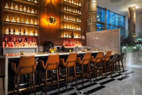 a bar with a row of chairs in a room at Sheraton Grand Los Angeles in Los Angeles