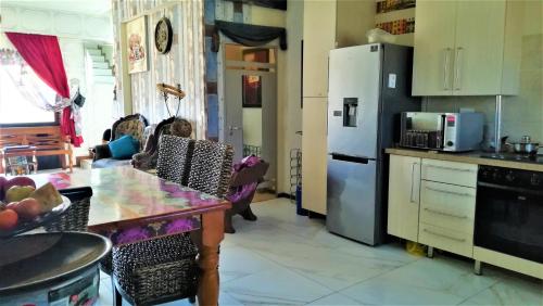 a kitchen with a refrigerator and a table in it at Lonehill in Sandton
