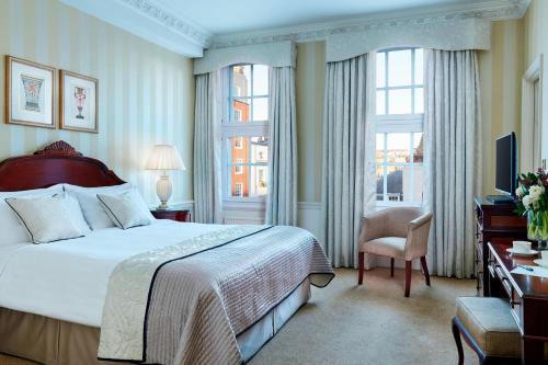 una camera d'albergo con letto, scrivania e finestra di Grand Residences by Marriott - Mayfair-London a Londra