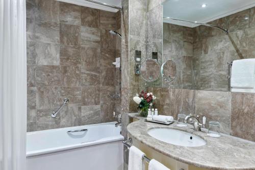 a bathroom with a tub and a sink and a bath tub at Grand Residences by Marriott - Mayfair-London in London