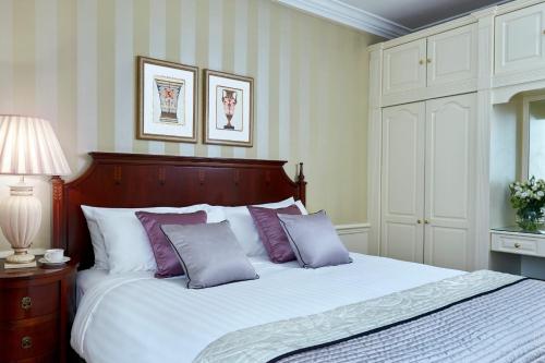 a bedroom with a bed with purple and white pillows at Grand Residences by Marriott - Mayfair-London in London