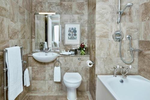 a bathroom with a toilet and a sink and a shower at Grand Residences by Marriott - Mayfair-London in London