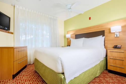 a hotel room with a large bed and a television at TownePlace Suites Houston Brookhollow in Houston
