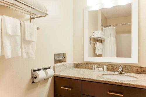 a bathroom with a sink and a mirror and towels at TownePlace Suites Houston Brookhollow in Houston