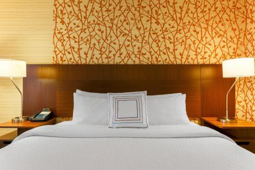 Cette chambre comprend un lit avec deux lampes et un mur. dans l'établissement Fairfield Inn & Suites by Marriott Yuma, à Yuma