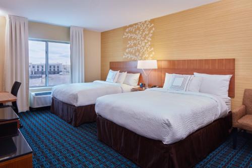 ローリンズにあるFairfield Inn & Suites by Marriott Rawlinsのベッド2台と窓が備わるホテルルームです。