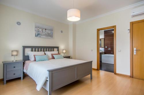 une chambre avec un grand lit et une salle de bain dans l'établissement Villa Casa Vilas Boas, à Albufeira