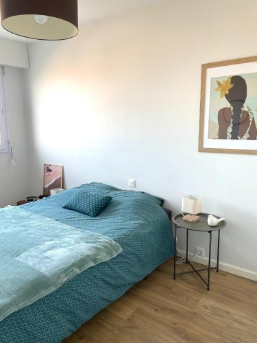 une chambre avec un lit et une table de chevet dans l'établissement La Petite Case - Face Mer, à Les Sables-dʼOlonne