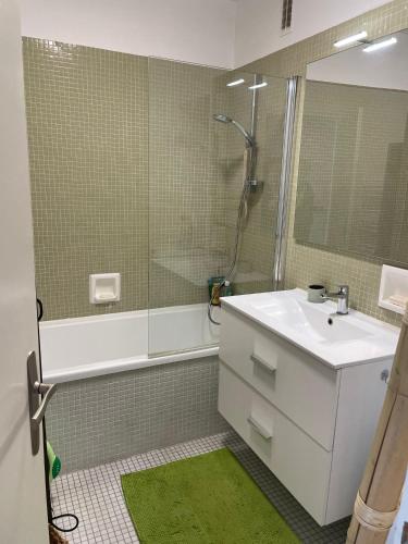 une salle de bain avec un lavabo blanc et une douche dans l'établissement La Petite Case - Face Mer, à Les Sables-dʼOlonne