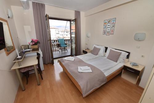 a bedroom with a bed and a desk and a window at House Lucija in Ohrid