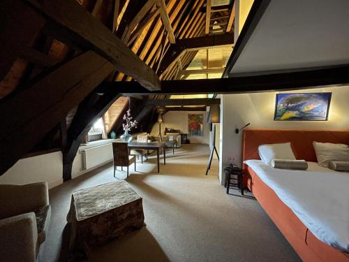 a bedroom with a large bed and a dining room at Hampshire Hotel - 's Gravenhof Zutphen in Zutphen