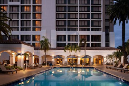 a hotel with a swimming pool in front of a building at Palm Beach Gardens Marriott in Palm Beach Gardens