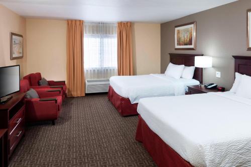 a hotel room with two beds and a flat screen tv at TownePlace Suites by Marriott Texarkana in Texarkana