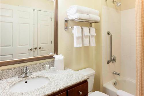 a bathroom with a sink and a toilet and a mirror at TownePlace Suites by Marriott Texarkana in Texarkana