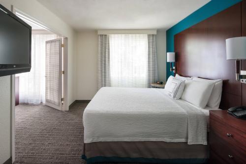 a hotel room with a bed and a flat screen tv at Residence Inn Pleasant Hill Concord in Pleasant Hill