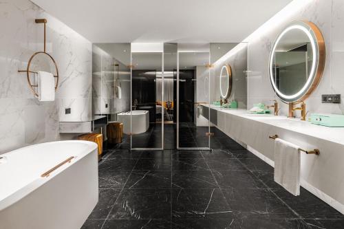 台中的住宿－台中李方艾美酒店，浴室设有2个水槽、浴缸和镜子