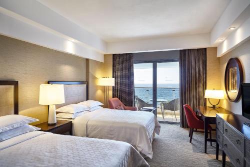een hotelkamer met 2 bedden en uitzicht op de oceaan bij Sheraton Grand Rio Hotel & Resort in Rio de Janeiro