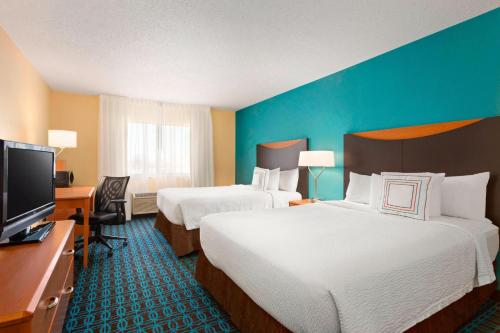 a hotel room with two beds and a flat screen tv at Fairfield Inn & Suites Mankato in Mankato