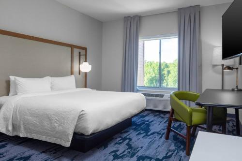 a hotel room with a bed and a desk and a chair at Fairfield Inn & Suites Rocky Mount in Rocky Mount