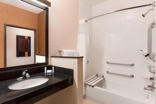 a bathroom with a sink and a tub and a mirror at Fairfield Inn & Suites Mankato in Mankato