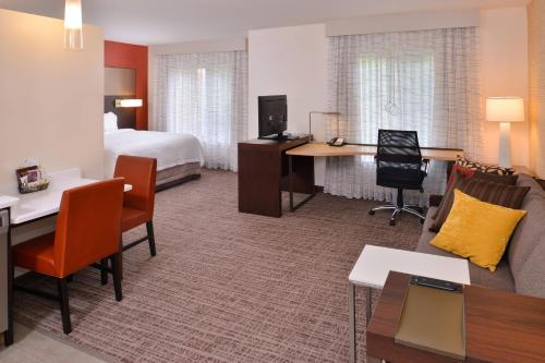 Residence Inn by Marriott East Lansing في إيست لانسنغ: فندق غرفه بسرير وصاله