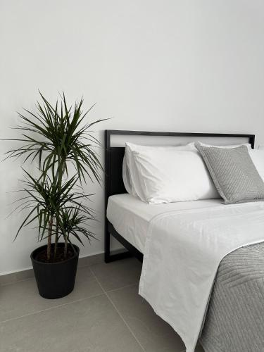 a bedroom with a bed and two potted plants at A drop from the sea in Finikas