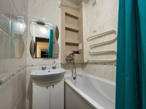 ein weißes Badezimmer mit einem Waschbecken und einer Badewanne in der Unterkunft 2к квартира Велика Васильківська 118, Палац Україна in Kiew
