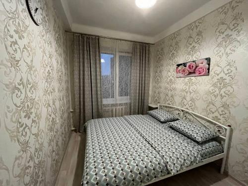Schlafzimmer mit einem Bett und einem Fenster in der Unterkunft 2к квартира Велика Васильківська 118, Палац Україна in Kiew