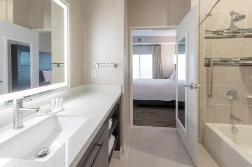 baño con 2 lavabos, ducha y cama en Residence Inn by Marriott St. Cloud en Waite Park