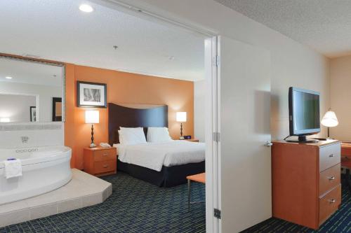 a hotel room with a bed and a tub and a television at Fairfield Inn & Suites Oakland Hayward in Hayward